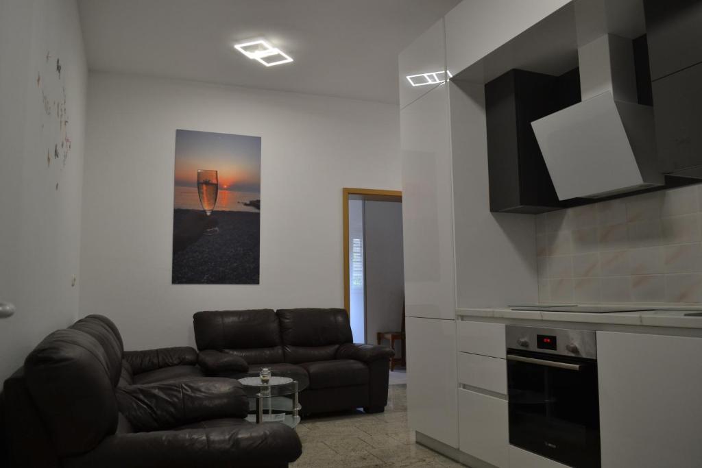 a living room with a leather couch and a kitchen at Villa Baldi -Apartmani Danny in Tar