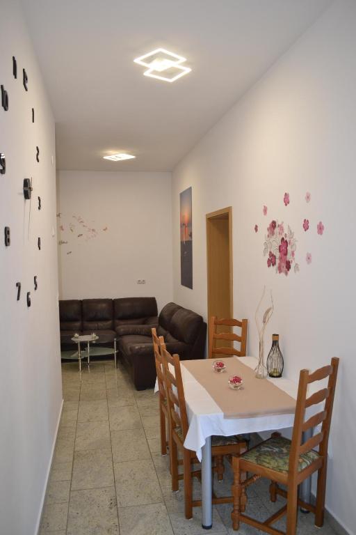 a living room with a table and chairs and a couch at Villa Baldi -Apartmani Danny in Tar