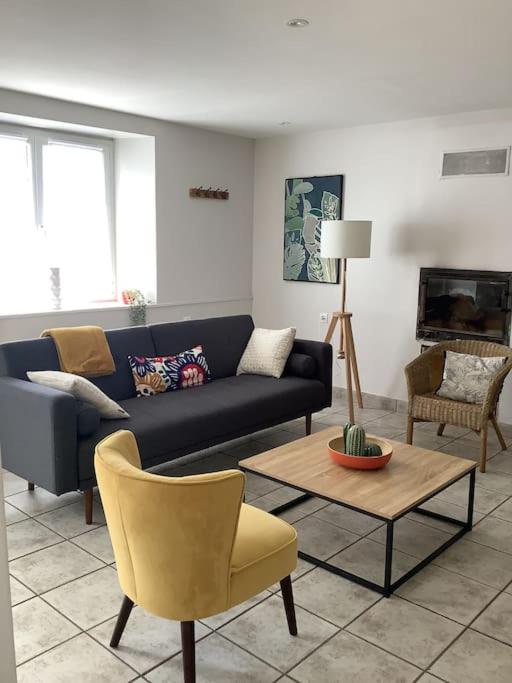 a living room with a blue couch and a table at Le petit Four Neuf in Lézardrieux