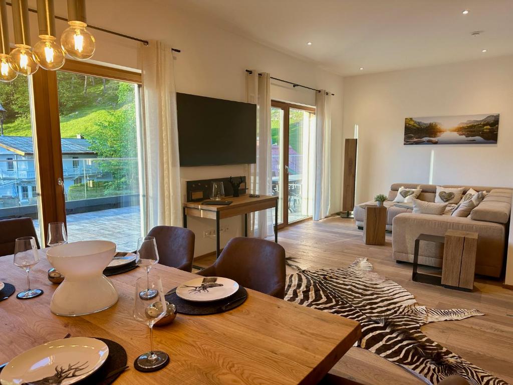uma sala de estar com uma mesa de madeira e uma sala de jantar em Penthouse Bergseetraum mit 102 qm Dachterrasse em Walchsee