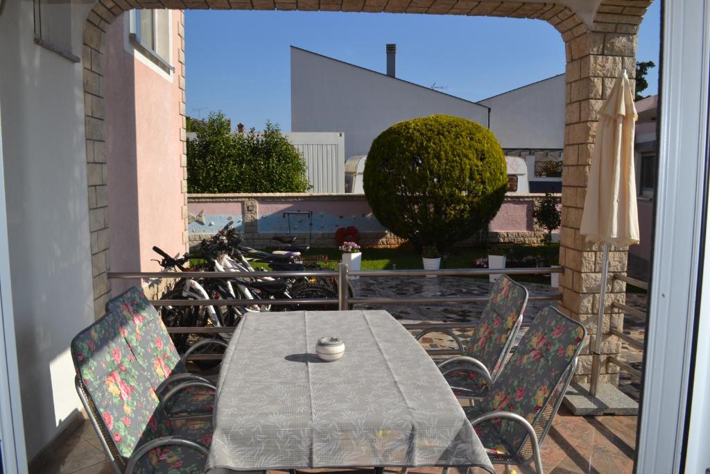 a table and chairs on a balcony with a view of a building at Villa Baldi -Apartmani Danny in Tar