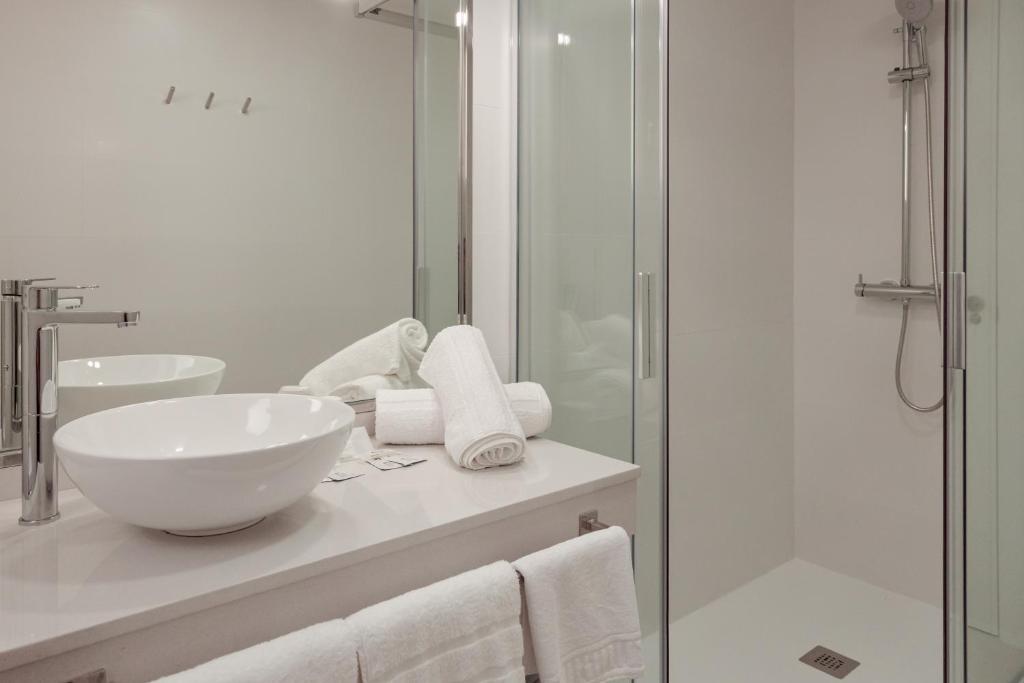 a bathroom with a sink and a glass shower at Hotel Jucamar in Cangas de Morrazo