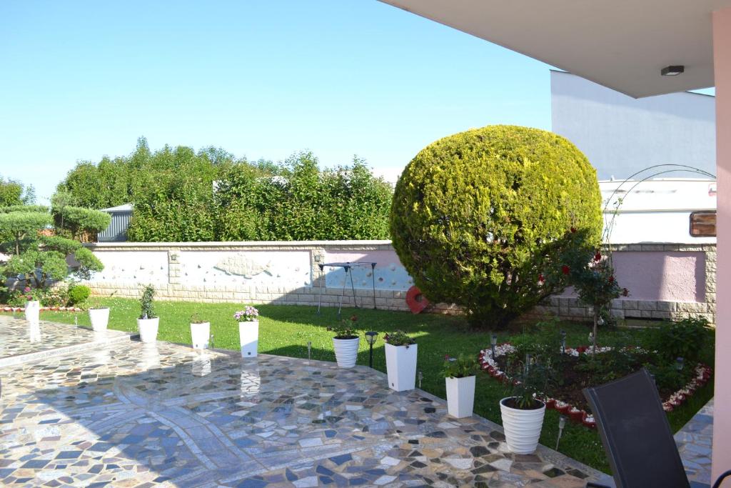 a garden with a bunch of white pots of flowers at Villa Baldi -Apartmani Danny in Tar
