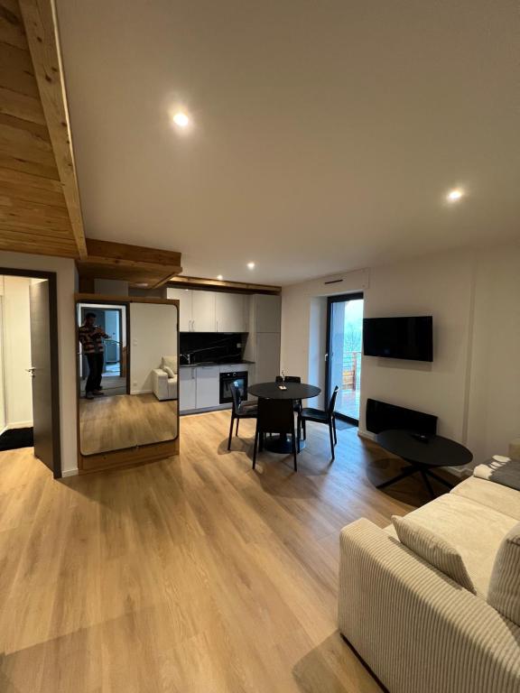 een woonkamer met een bank en een tafel bij Superbe appartement neuf avec Sauna privé & Terrasse vue sur la montagne in La Bresse