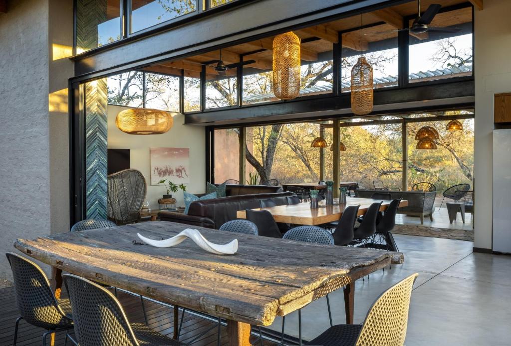 Rixile Kruger Lodge في سكوكوزا: غرفة طعام مع طاولة وكراسي خشبية