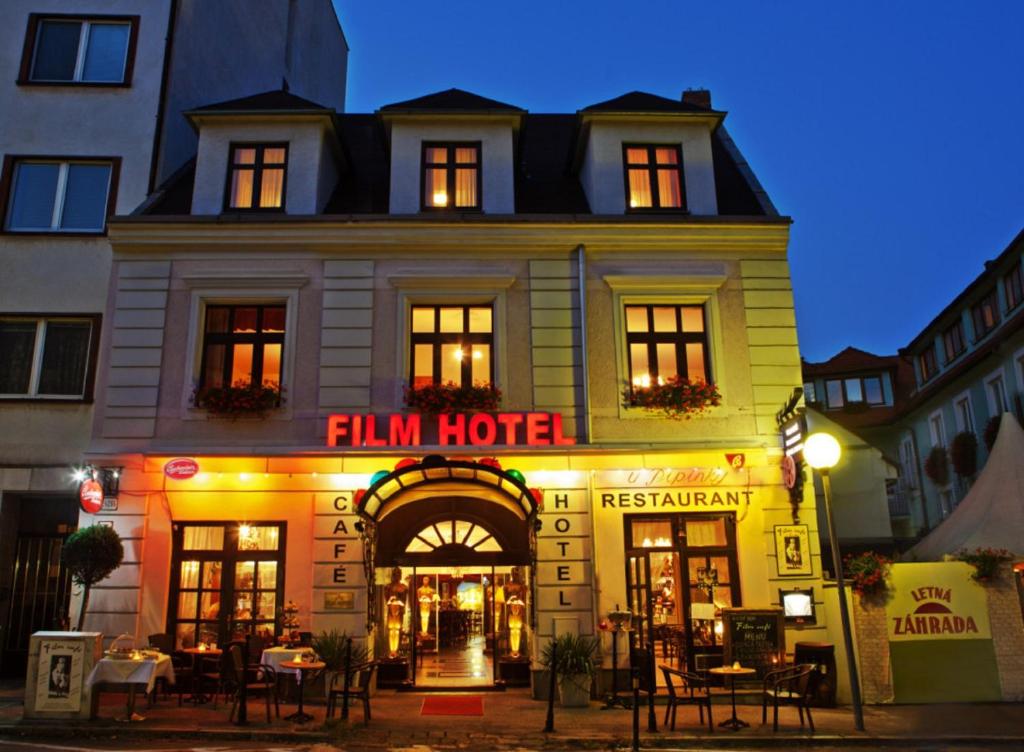 a building with aeln hotel on a street at night at Film Hotel in Bratislava