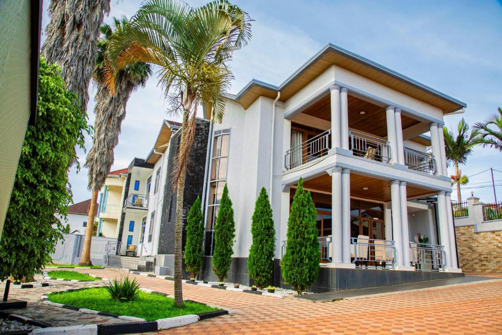 une maison avec des palmiers devant elle dans l'établissement NETLUNA VILLA HOTEL, à Kigali