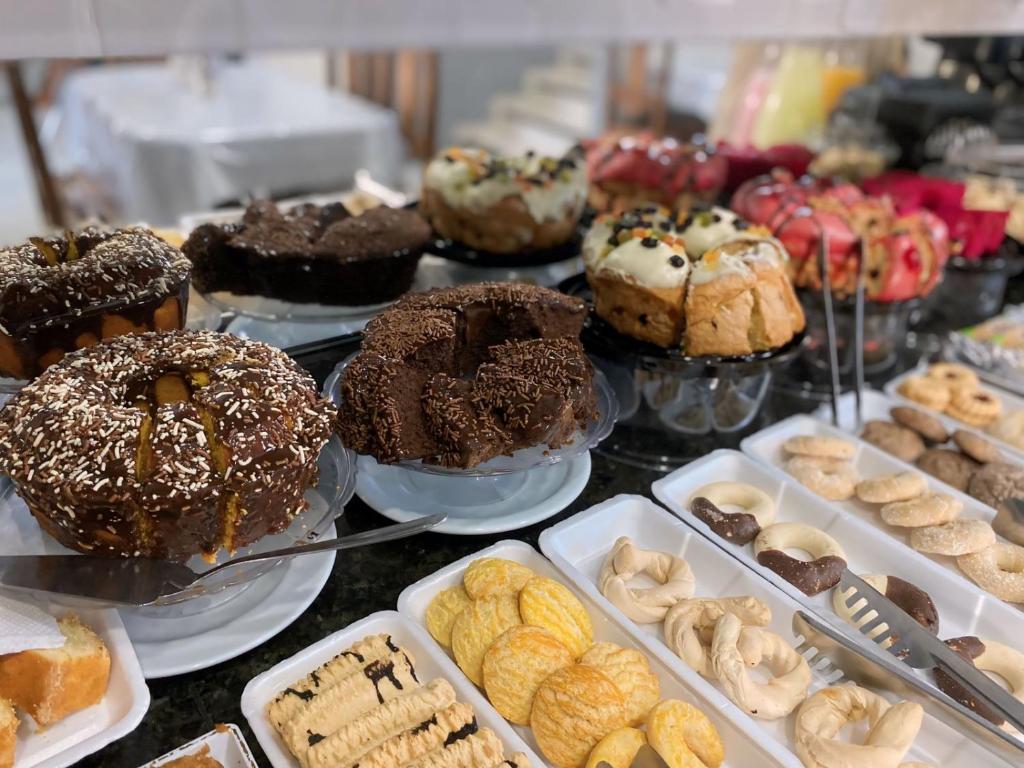 a display of different types of donuts and pastries at Pousada Itaguaçu in Aparecida