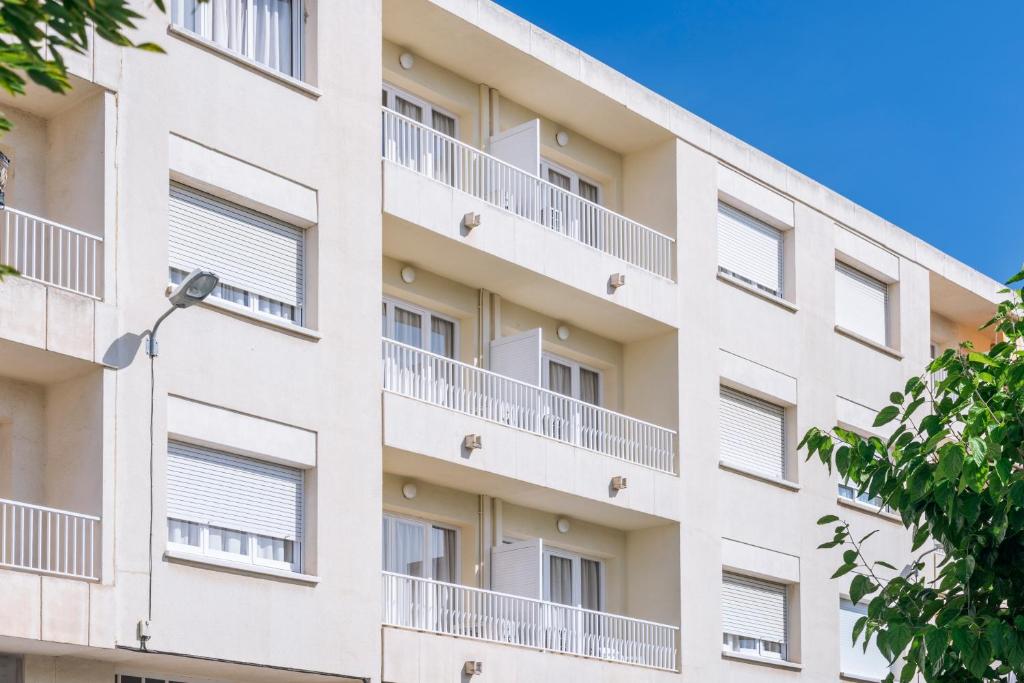 um edifício de apartamentos com varandas e uma luz de rua em Apartments Sorrabona em Pineda de Mar