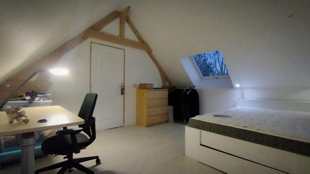 - une chambre avec un lit, un bureau et une table dans l'établissement Housse Chaleureuse et Confortable, à Osny