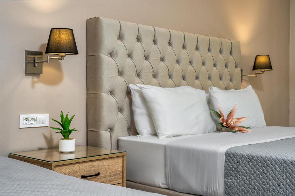 a bedroom with a large bed with a large padded headboard at Rania's Deluxe Studios in Tsilivi
