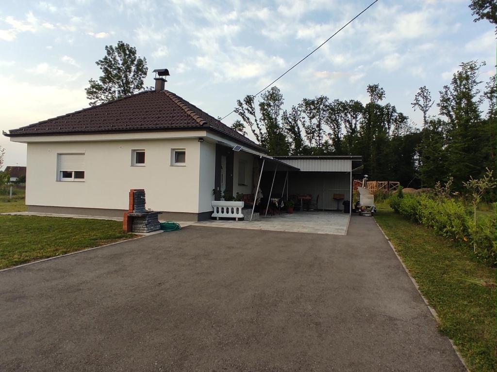 a white house with a driveway in front of it at Vikendica Ninic in Laktaši