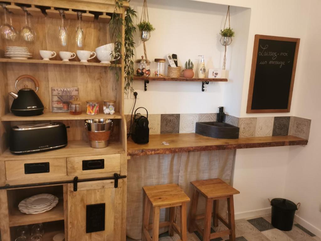 a kitchen with a counter and some wooden stools at La petite maison dans les nuages in Tourtour