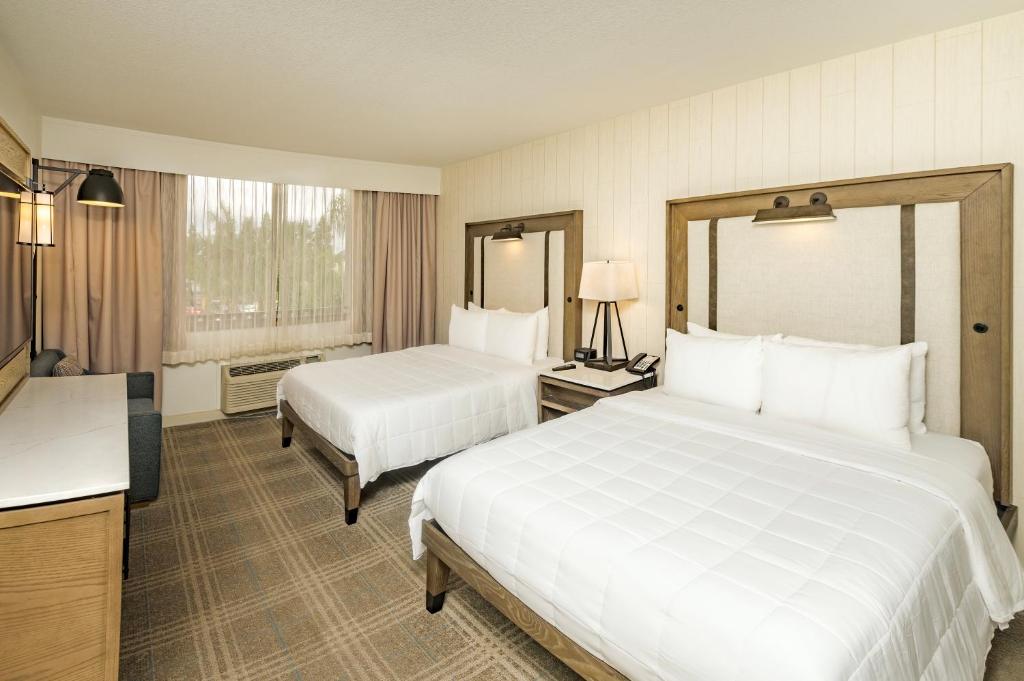 a hotel room with two beds and a television at Knott's Hotel in Buena Park