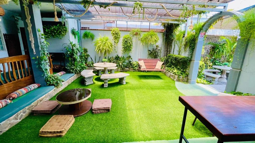 利比里亞的住宿－Hostel El Pretal，一个带绿草的庭院,以及一张桌子和长凳