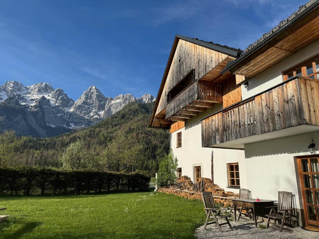 a house with a table and chairs and mountains at Country House Trata in Kranjska Gora