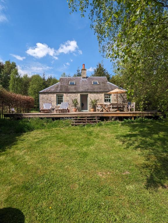 a house with a deck with two chairs on it at Birkenside Cottage in Jedburgh