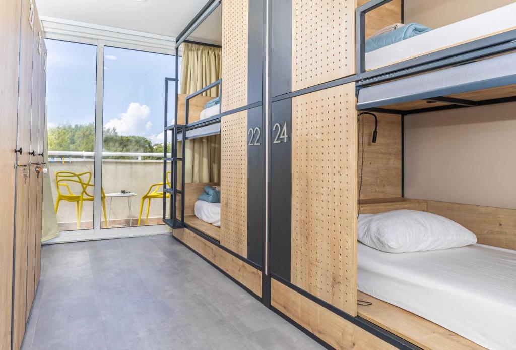 ドゥブロヴニクにあるホステル ペトラ マリーナの二段ベッドとバルコニーが備わる客室です。