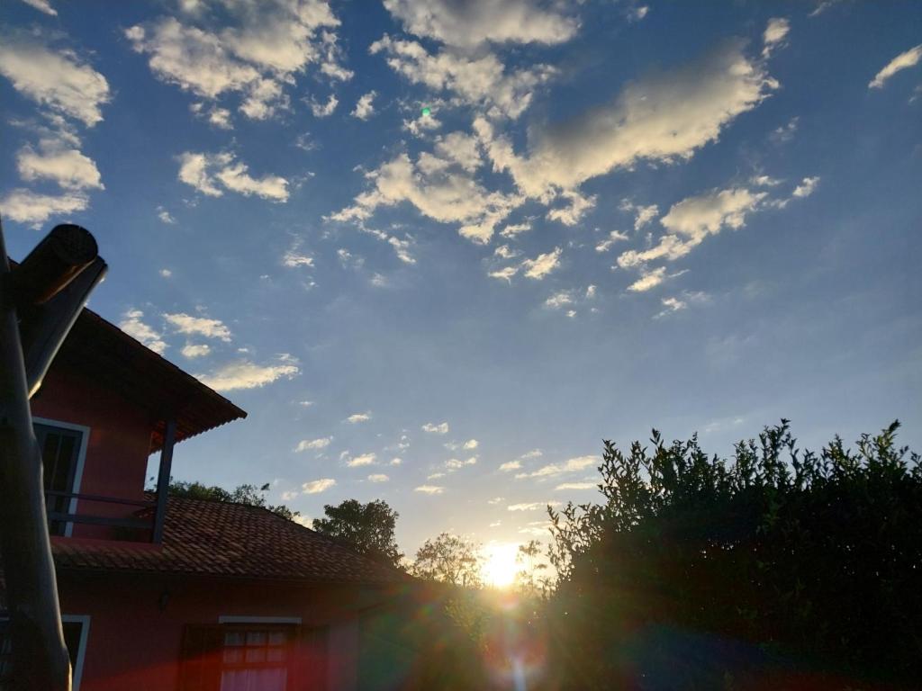 een bewolkte hemel met de zon achter een huis bij Villa Monni - Miguel Pereira in Miguel Pereira
