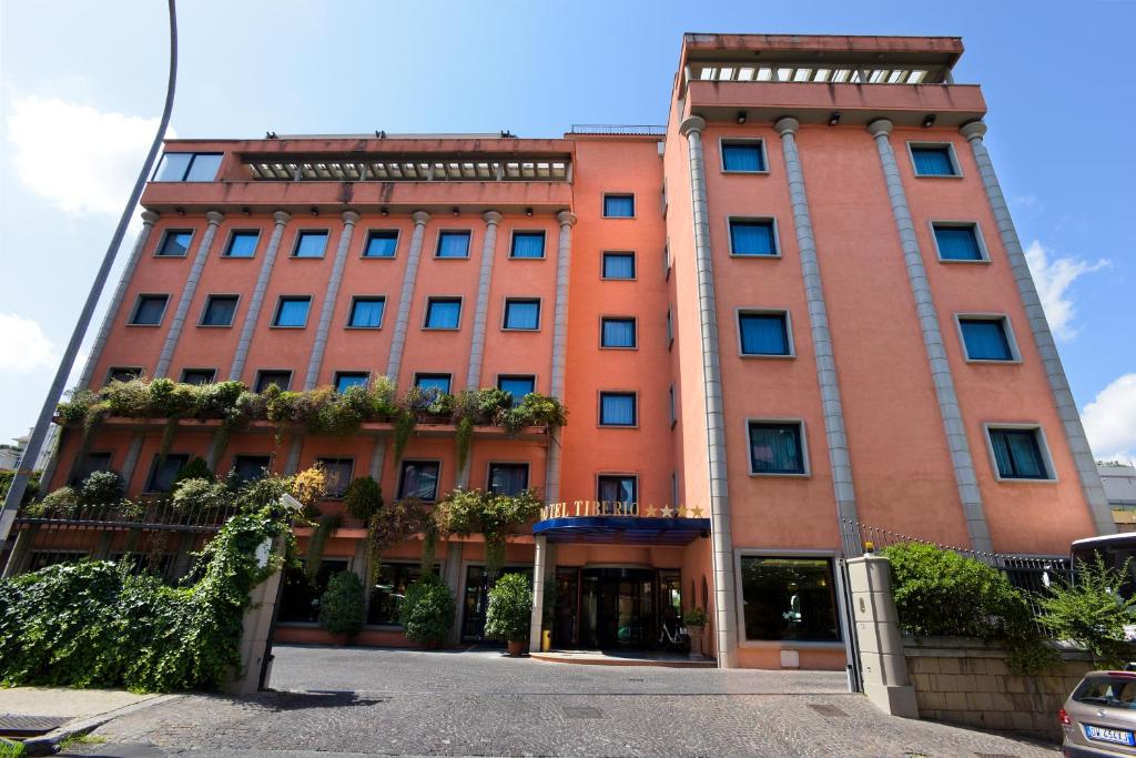 un grand bâtiment orange avec des plantes dans l'établissement Grand Hotel Tiberio, à Rome
