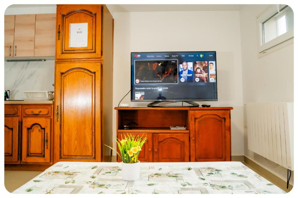 uma sala de estar com televisão num centro de entretenimento em madeira em Appartement confortable entre Paris et Disney em Villiers-sur-Marne