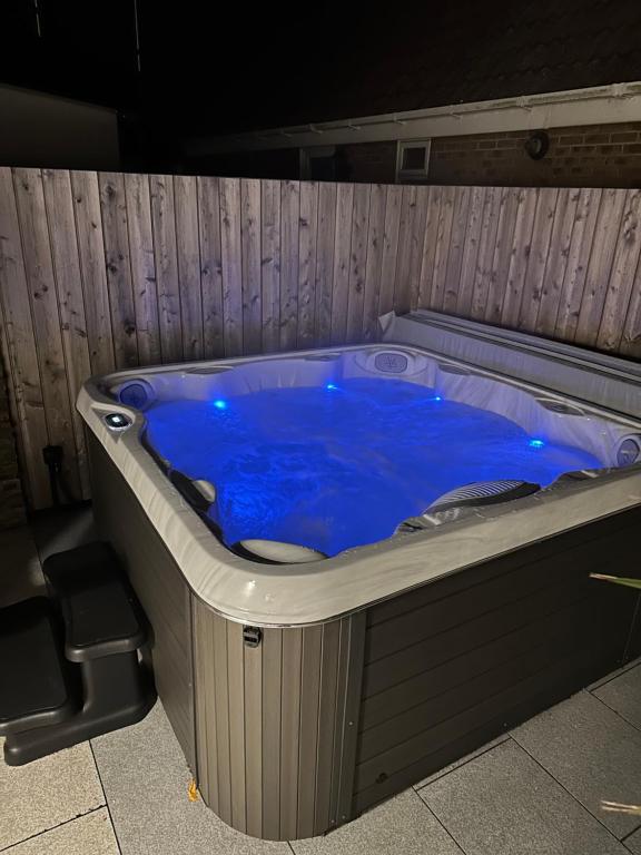 a large blue hot tub in a room at Coastal Courtyard with Hot Tub, Greatstone in Greatstone