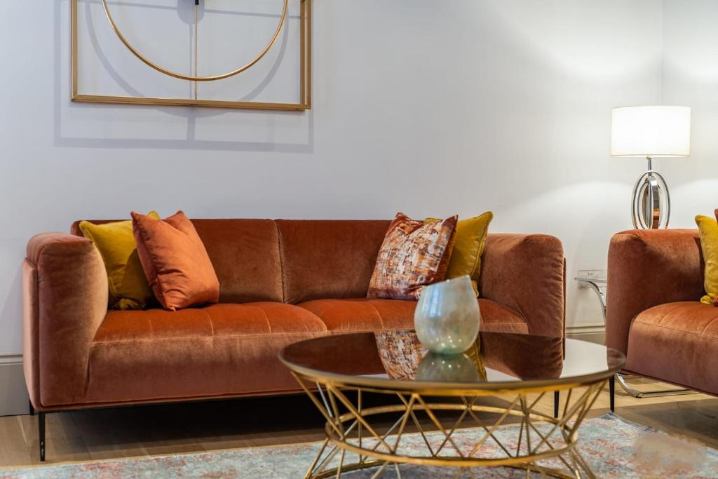 uma sala de estar com um sofá castanho e uma mesa em Mayfair - Exclusive 4 Bedroom Apartment em Londres