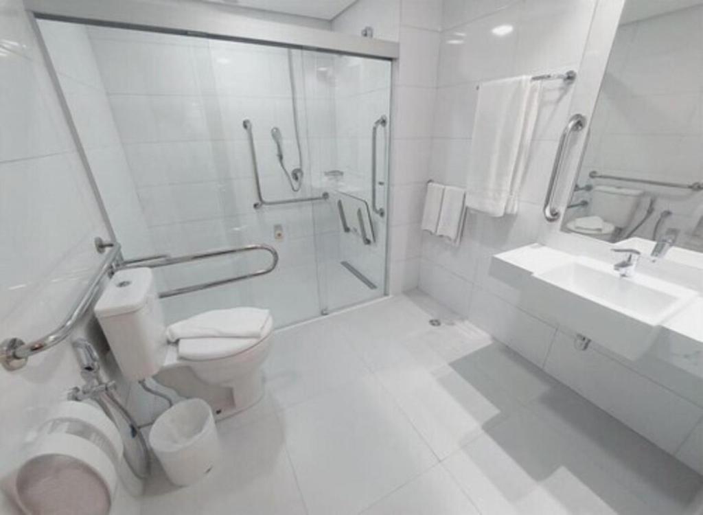 Baño blanco con aseo y lavamanos en Transamerica Executive Bela Cintra (Paulista) en São Paulo