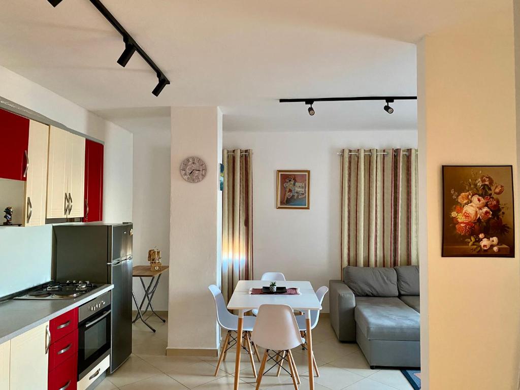 uma cozinha e sala de estar com uma mesa e um sofá em Eden Home em Durrës