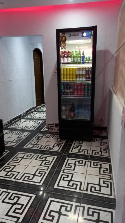a refrigerator filled with drinks on a tile floor at Hotel Ferrari in Sao Paulo