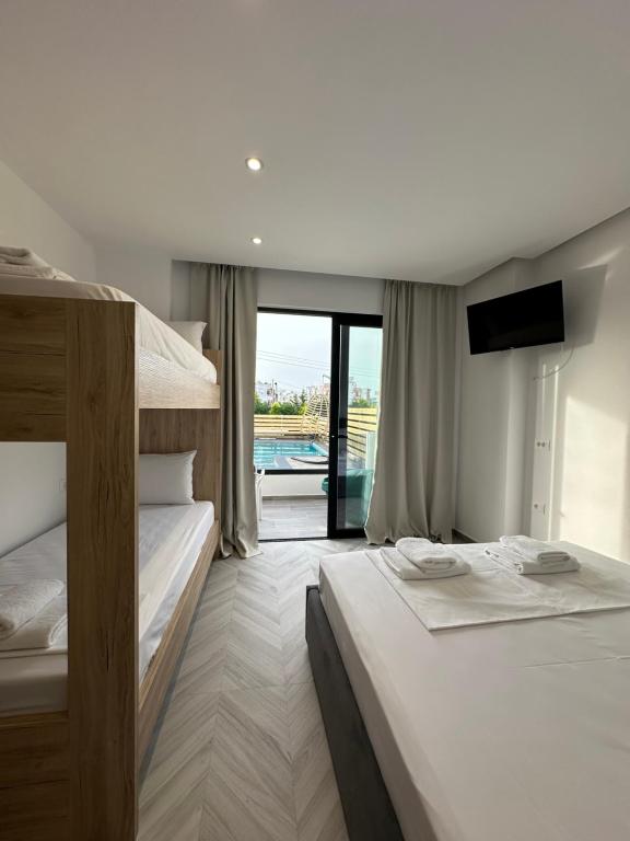 a hotel room with two beds and a balcony at Noa Boutique Hotel in Ksamil
