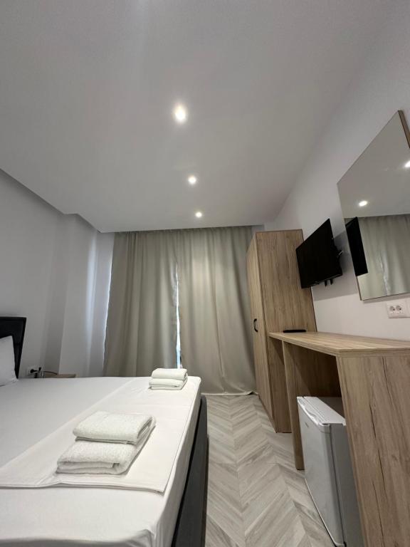 a bedroom with a bed with towels on it at Noa Boutique Hotel in Ksamil