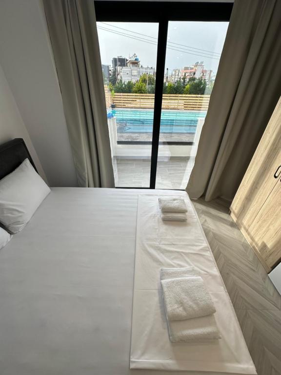 a hotel room with a bed with two towels on it at Noa Boutique Hotel in Ksamil