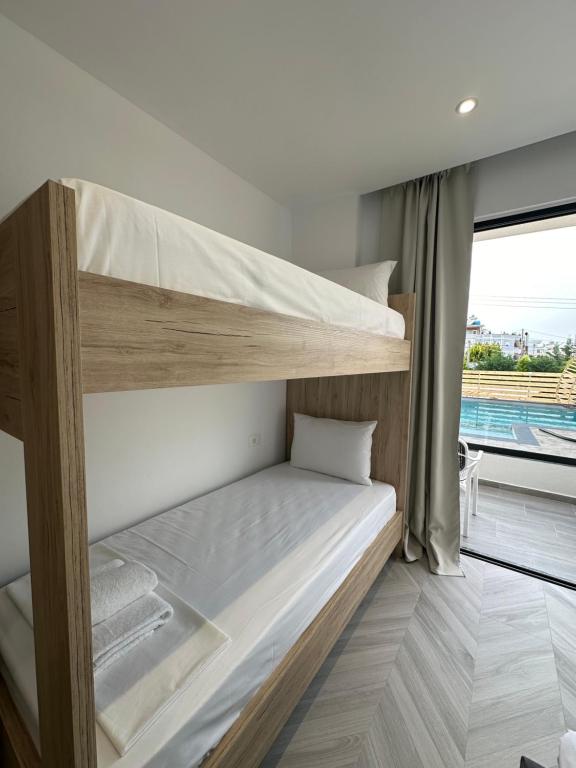 a bedroom with two bunk beds and a window at Noa Boutique Hotel in Ksamil