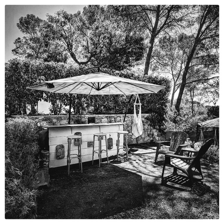 una foto en blanco y negro de un bar con sombrilla en superbe mobil home, climatisé, ss vis a vis, au calme, dans super domaine, en Fréjus