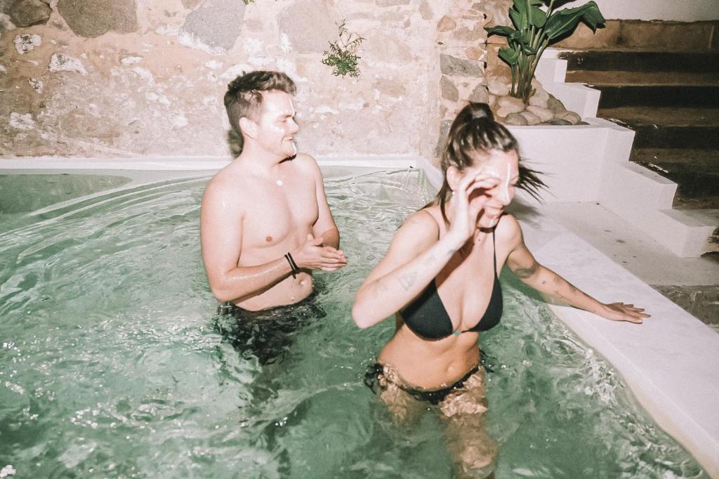 um homem e uma mulher numa banheira de hidromassagem em Casa Om em Dosríus