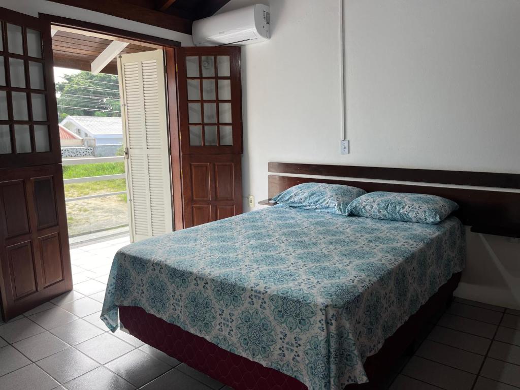 1 dormitorio con 1 cama y puerta abierta en Residencial Recanto do Sossego en Bombinhas