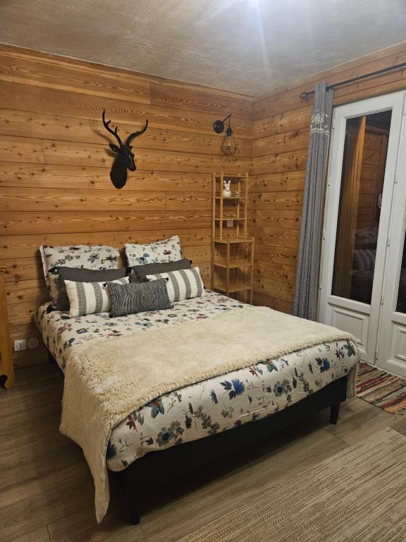 a bedroom with a bed in a wooden wall at Studio à 100 mètres du départ des pistes de ski in La Salle Les Alpes
