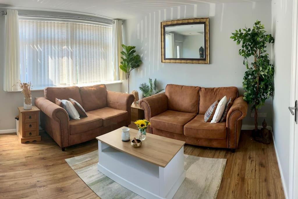 Sala de estar con 2 sofás y mesa de centro en Heathrow's Nest, en Hayes