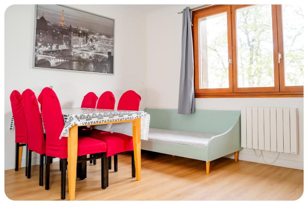 ein Esszimmer mit einem Tisch und roten Stühlen in der Unterkunft HAPPY HOUSE - PARKING - WiFI in Villiers-sur-Marne