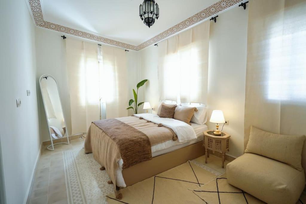 ein Schlafzimmer mit einem Bett und einem Stuhl darin in der Unterkunft Dar Badr in Tangier