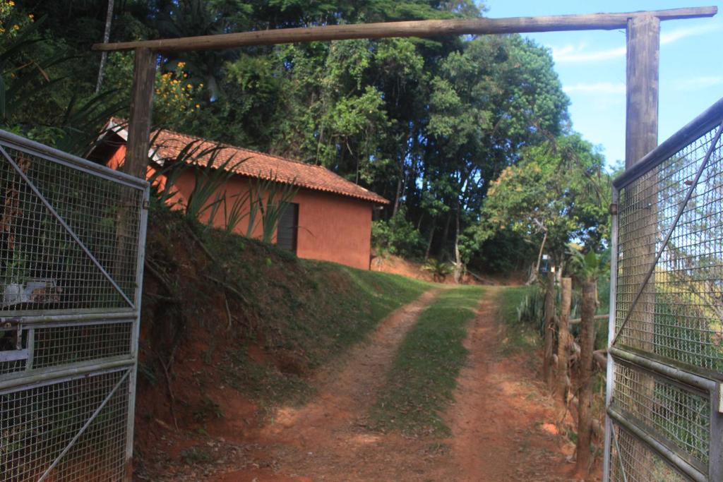 a dirt road in front of a house with a fence at Refúgio Leve Amor in Águas de Lindóia