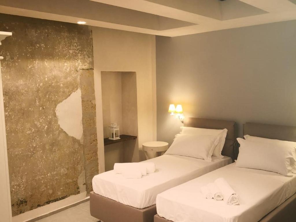 Cette chambre comprend deux lits et un tableau mural. dans l'établissement Vicoli di Napoli B&B, à Naples