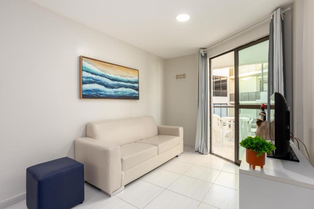 salon z białą kanapą i telewizorem w obiekcie Sea Residence w mieście Porto de Galinhas