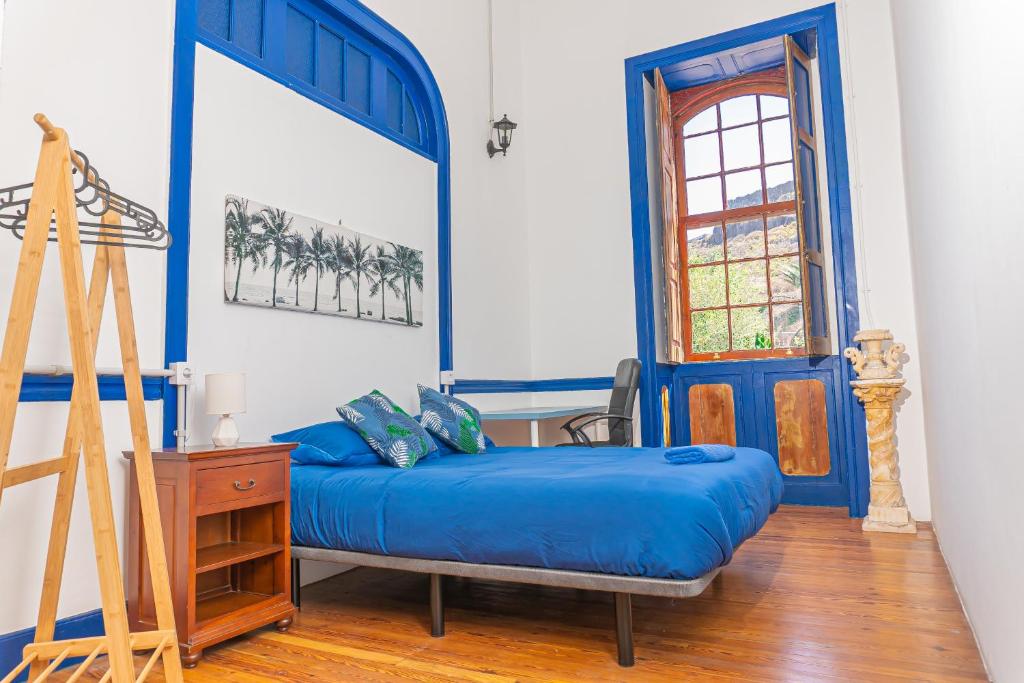 een slaapkamer met blauwe en witte muren en een bed bij Atlantis Surf Hostel in Moya