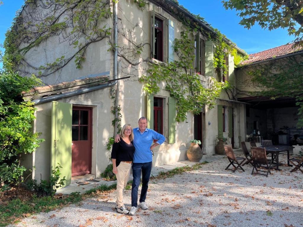un hombre y una mujer parados frente a un edificio en Le Mas Ferrand en Graveson