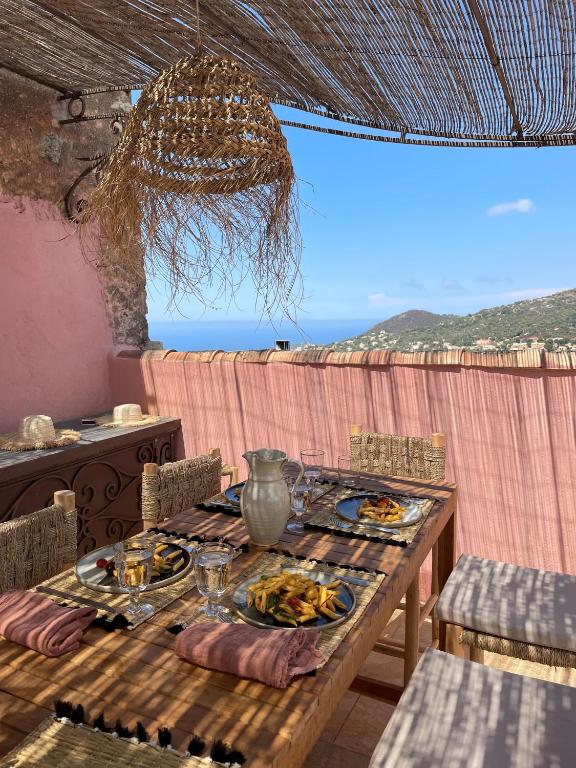 une table en bois avec des assiettes de nourriture dessus dans l'établissement Ravissante maison entre ile rousse et calvi, à Cateri