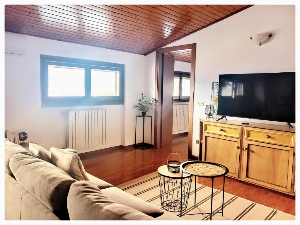 sala de estar con sofá y TV de pantalla plana en Appartamento in centro con vista lago a 5 minuti da Menaggio, en Acquaseria