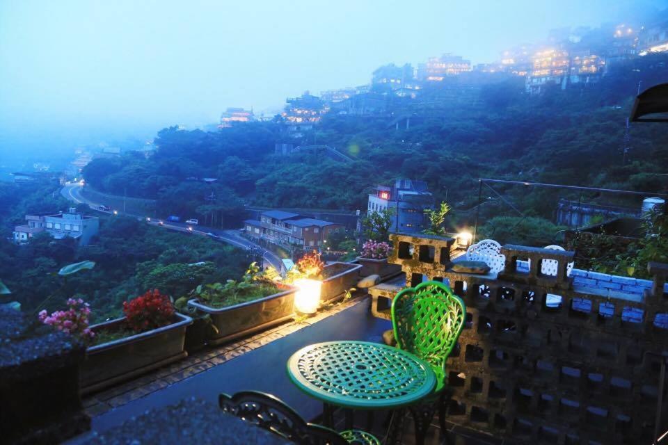 a table and chairs on a balcony with a view at Jiufen Walk Inn 3x3 in Jiufen