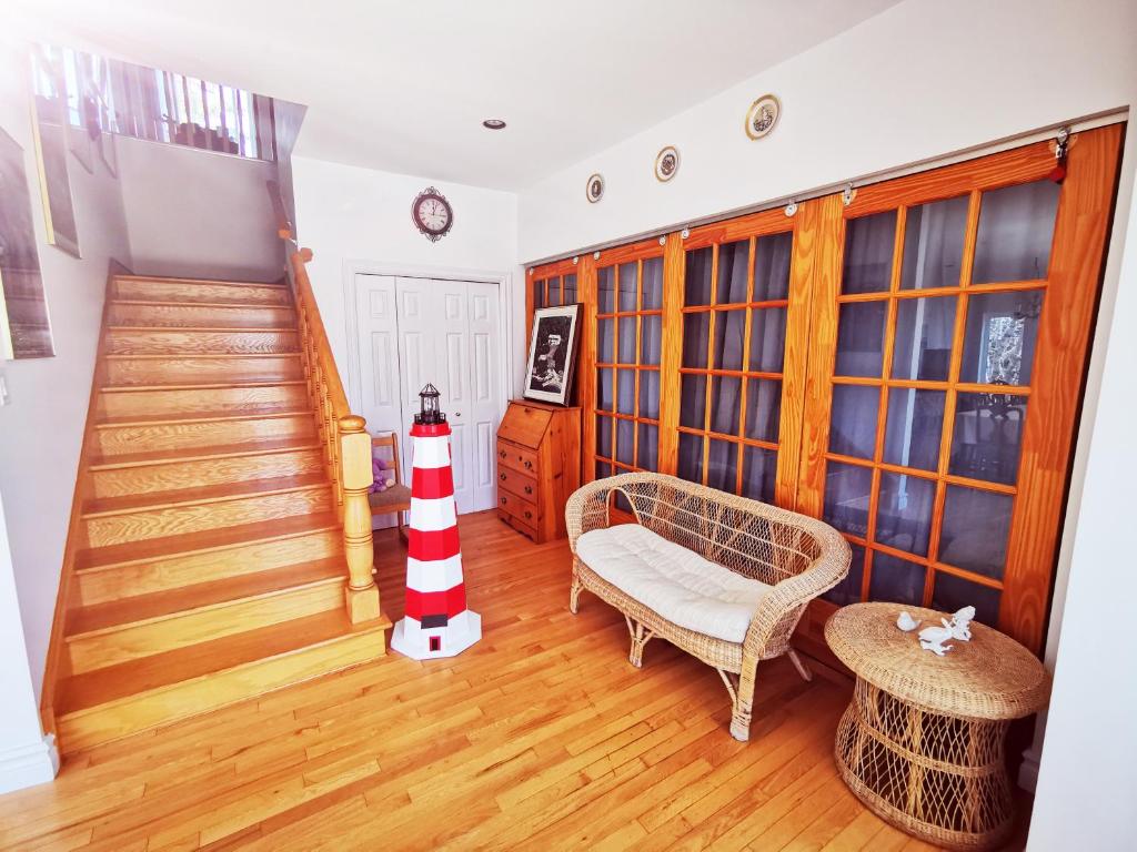 a living room with a staircase and a red and white lighthouse at 181 Oceanside Inn in Peggy's Cove